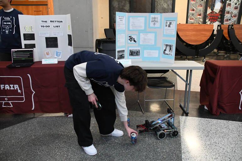 A student sets up soda cans for the VEX robot